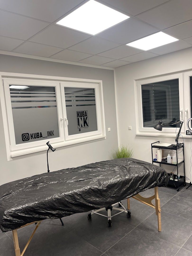 a black and white massage table in a room with windows