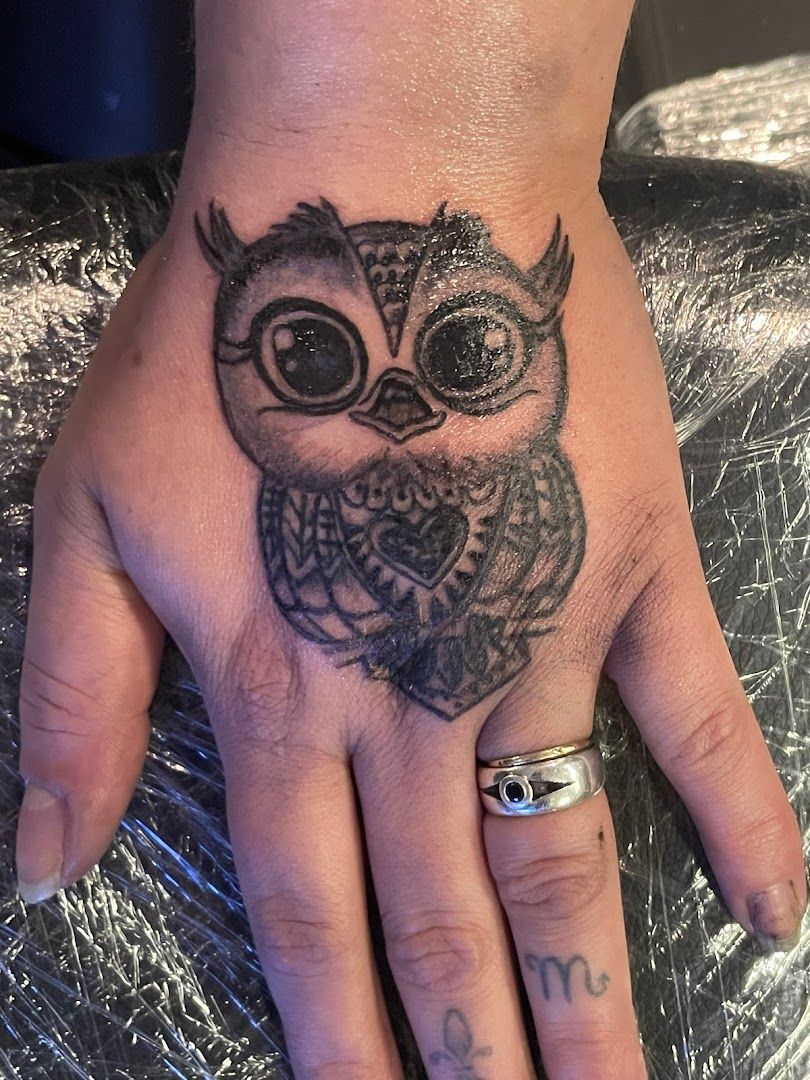 a narben tattoo of an owl on the hand, rosenheim, germany