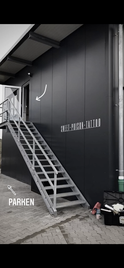 a black building with stairs and a white sign