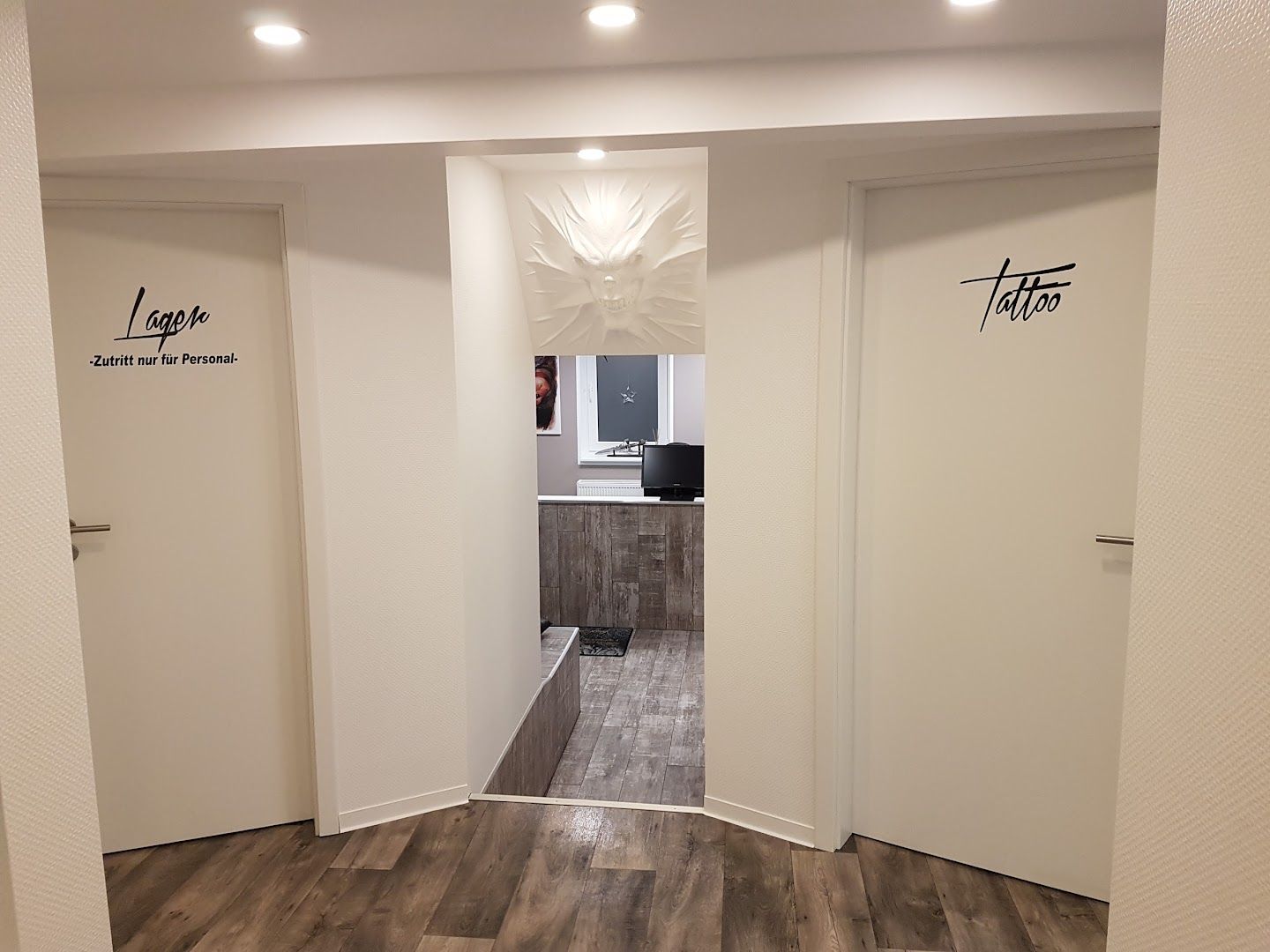 a hallway with white walls and wood floors