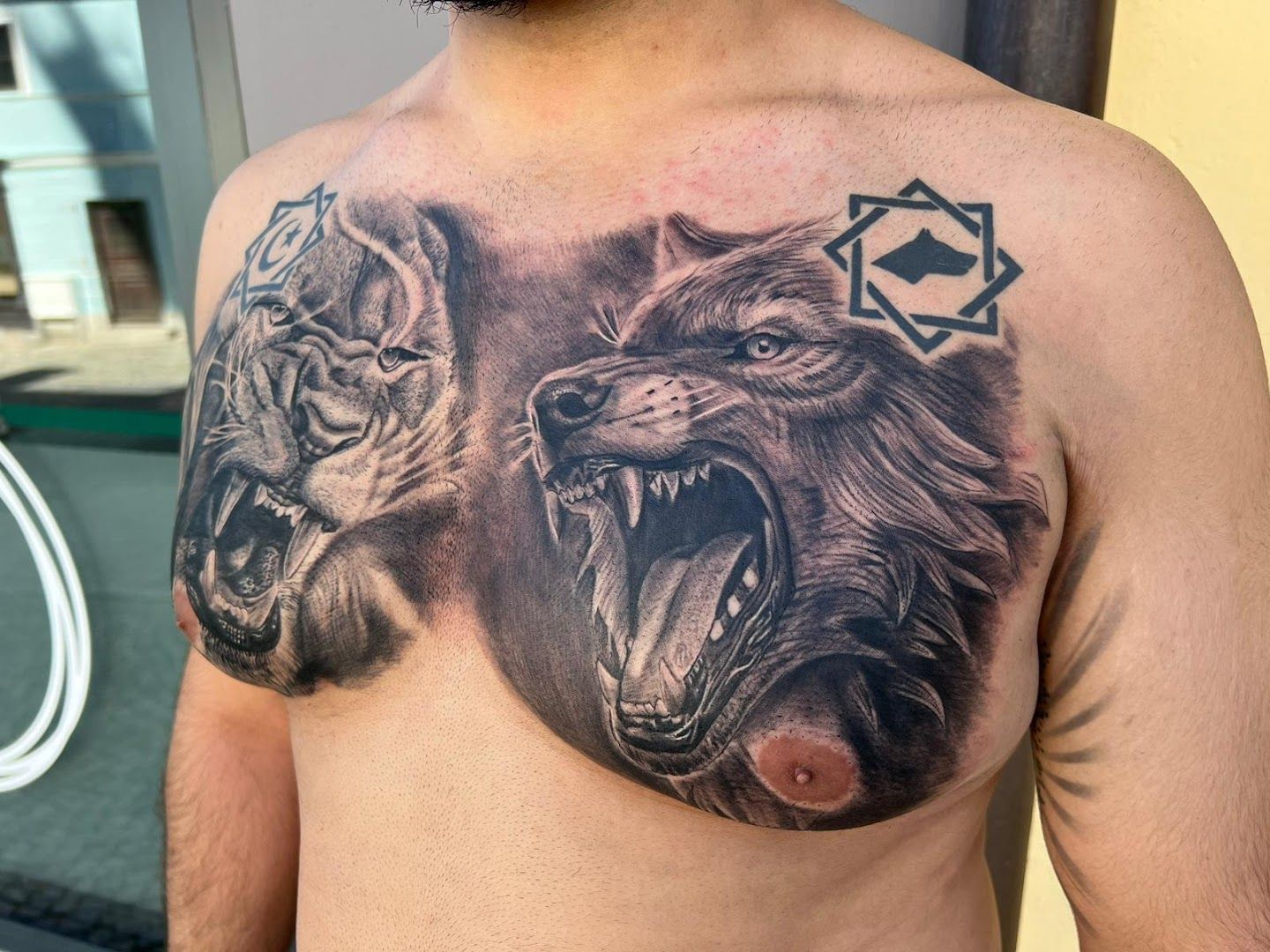 a man with a lion cover-up tattoo on his chest, dachau, germany