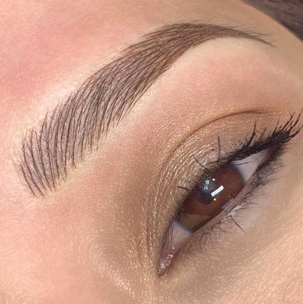 a woman's eye with long lashes and brown eyes