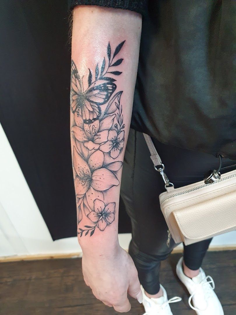 a woman's arm with a black and white flower cover-up tattoo, ansbach, germany