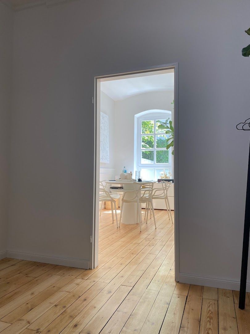 a white room with a wooden floor and a white wall