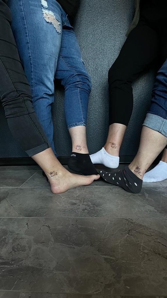 two people sitting on a couch with their feet up