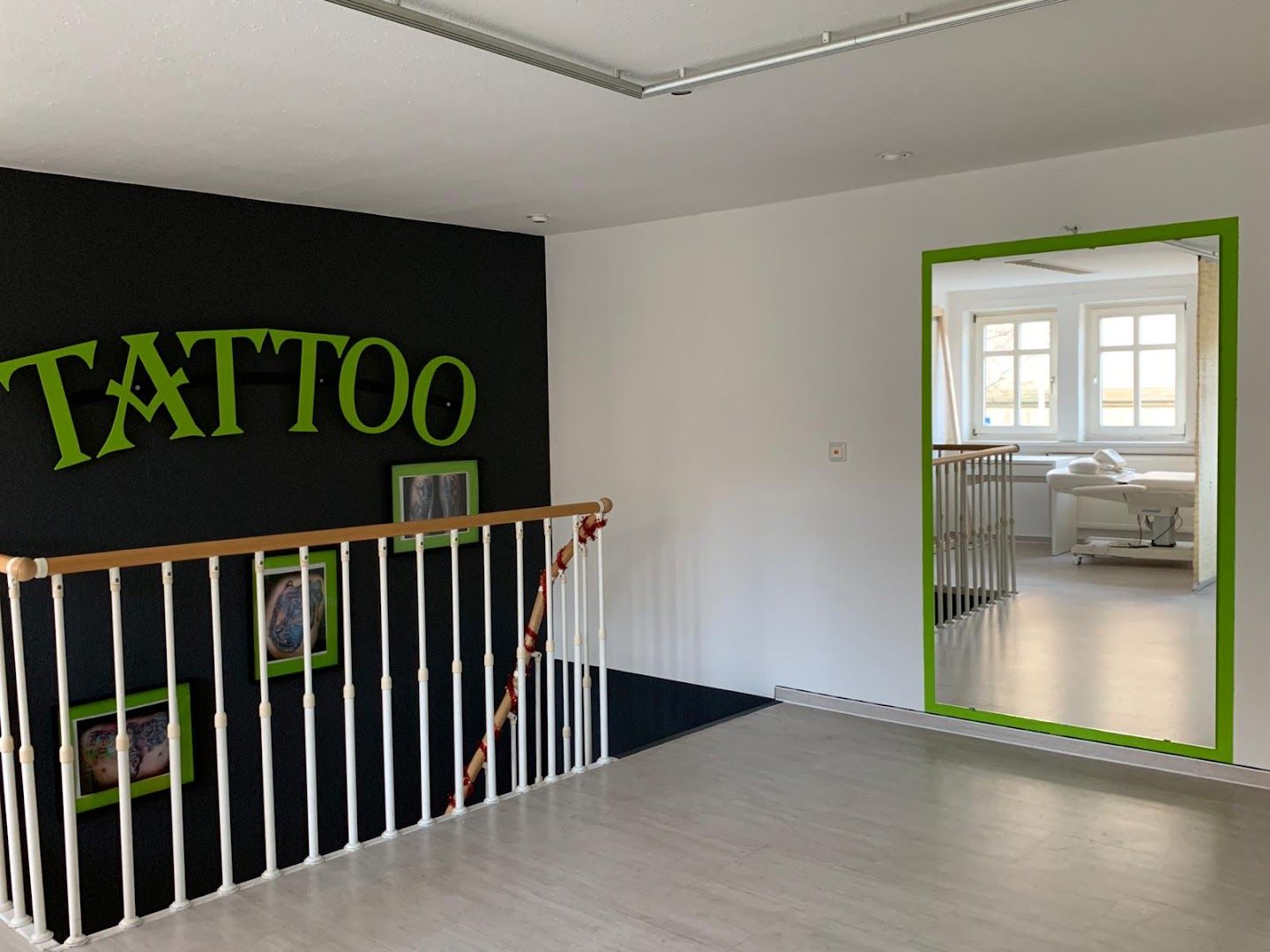 a black wall with green letters and a white railing