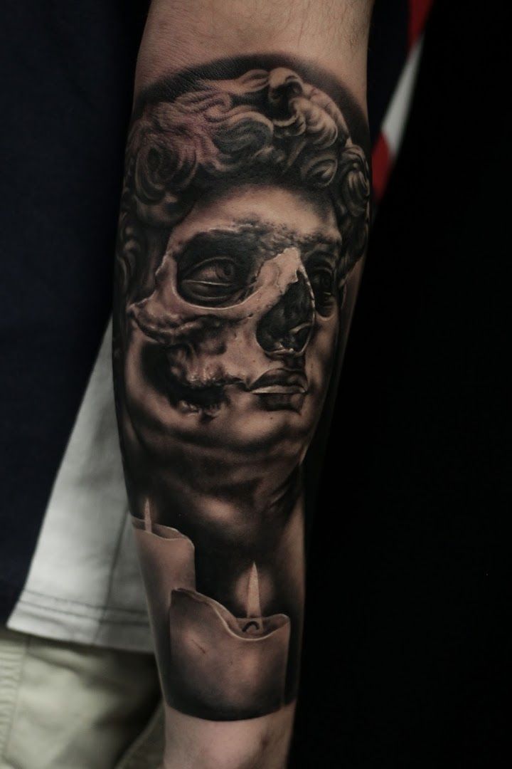 a man's arm with a skull and a cigarette