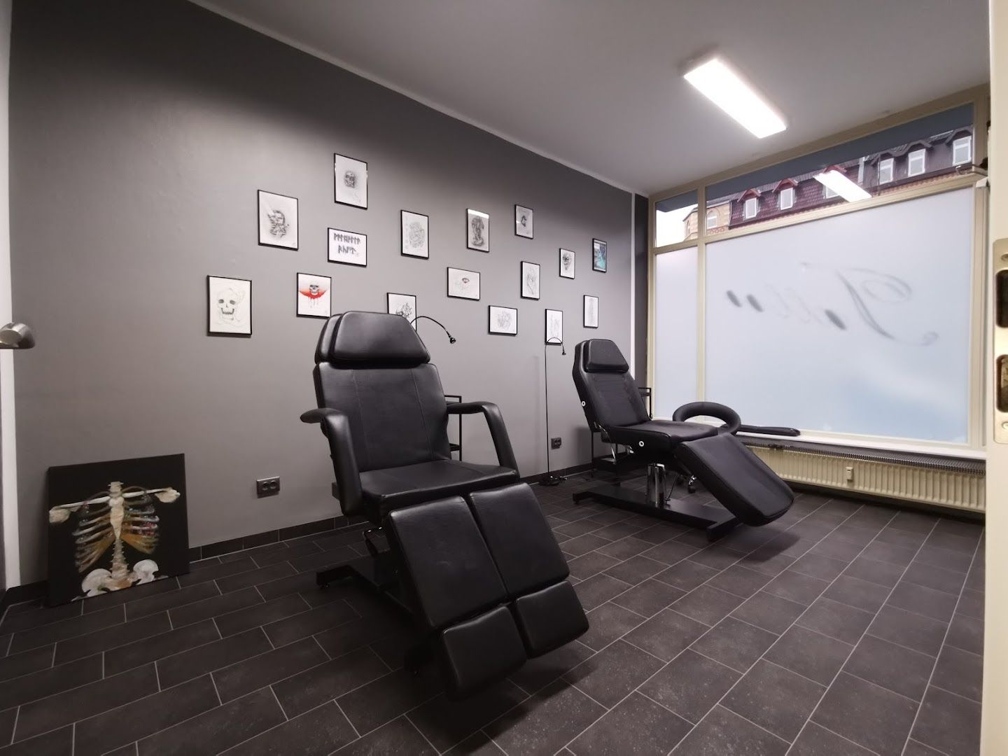 a salon room with black chairs and pictures on the wall