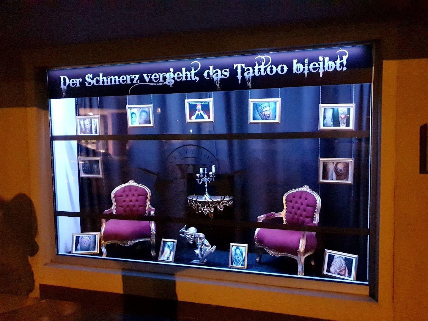 a window display with a pink chair and a black and white sign