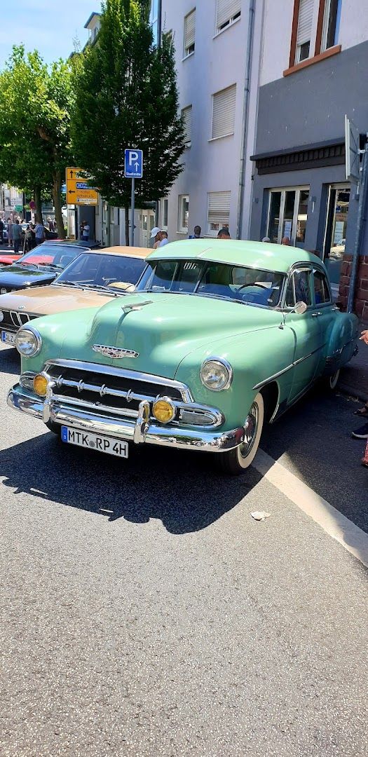 a green car parked in front of a building