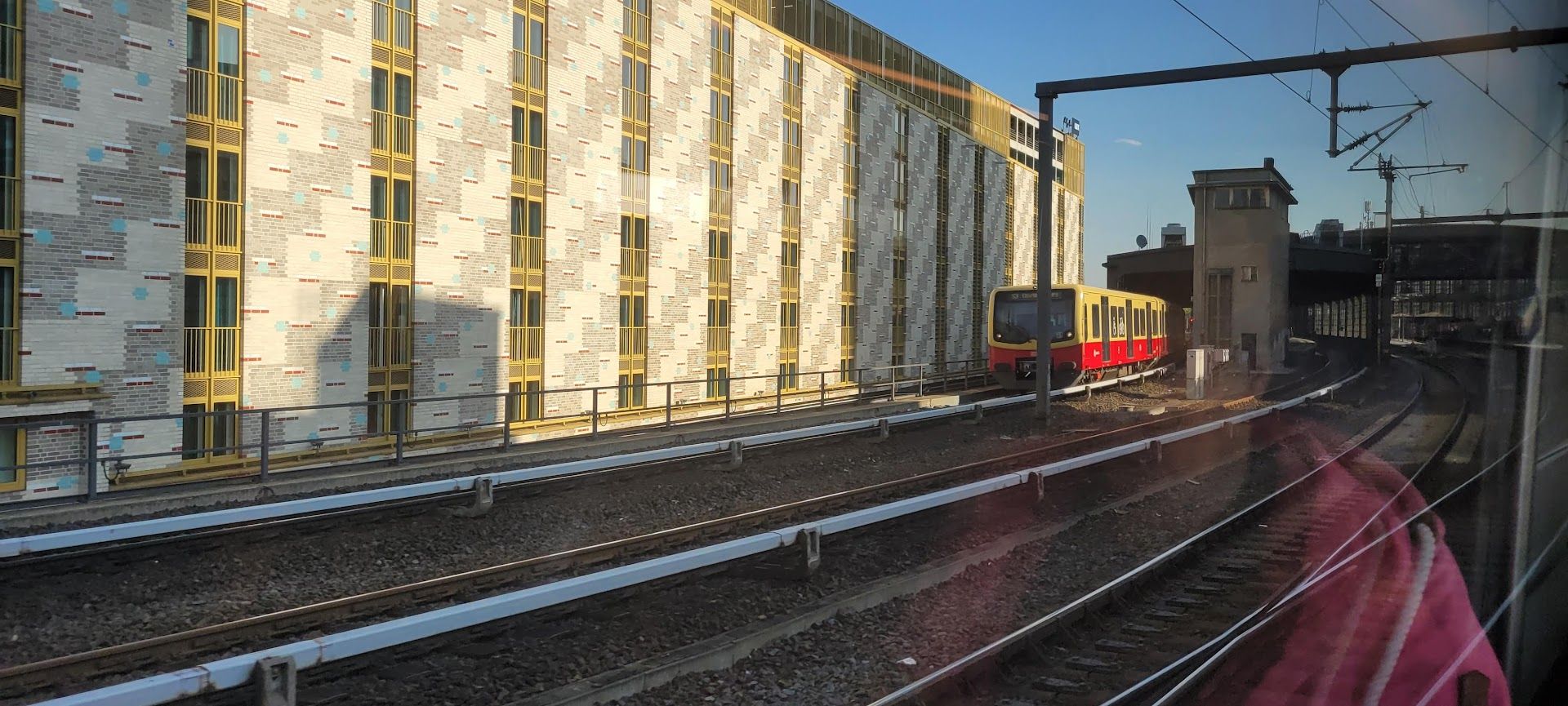 a train traveling down the tracks near a building