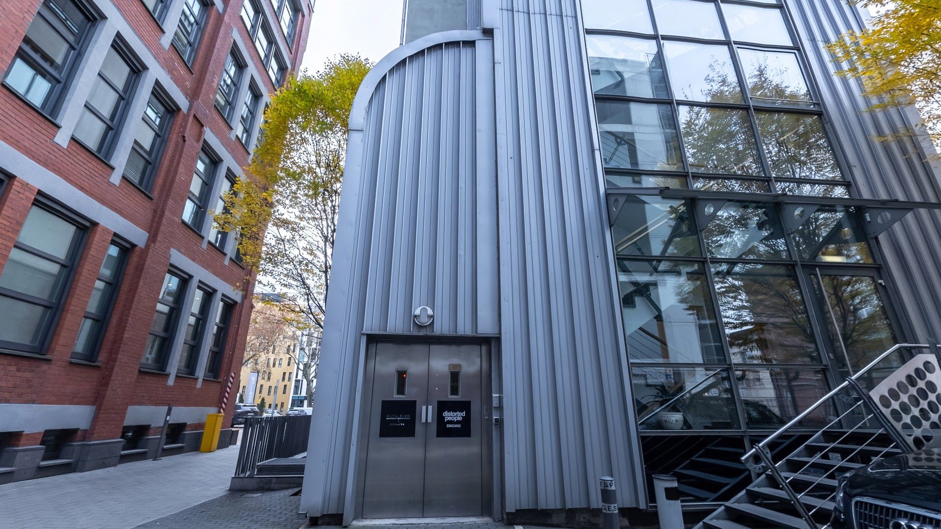 a tall building with a metal door and stairs