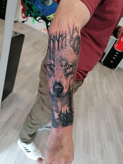 a man with a wolf cover-up tattoo on his arm, paderborn, germany