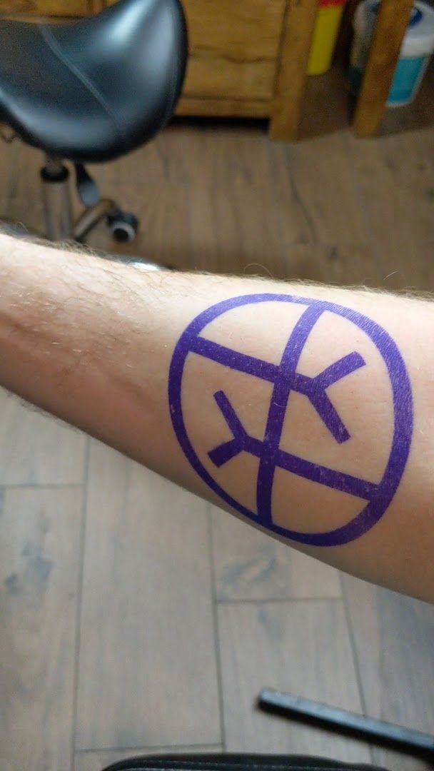 a man with a purple and black cover-up tattoo on his arm, hamburg, germany