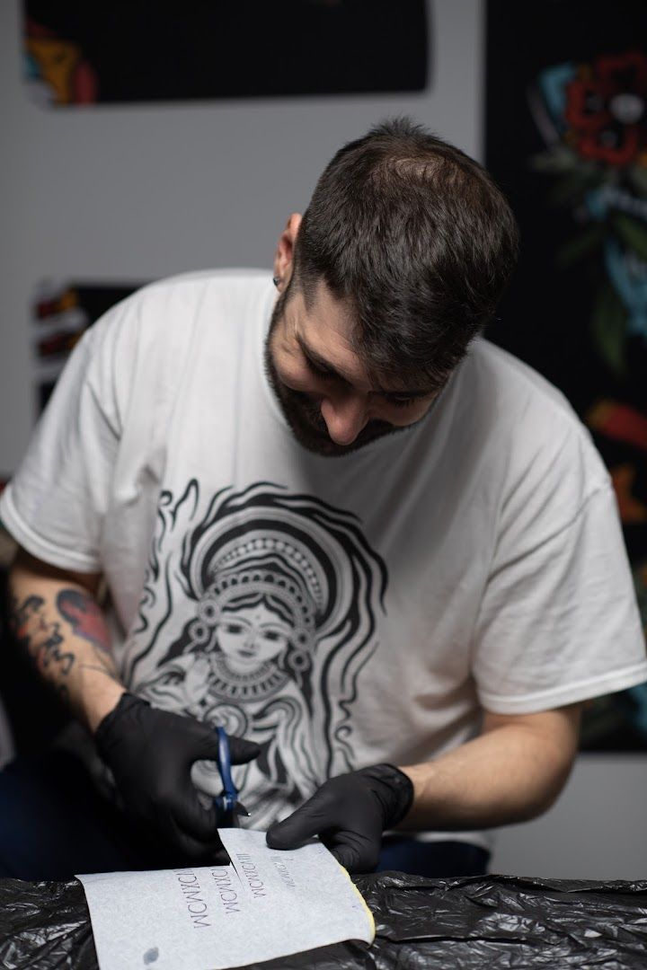 a man in a white shirt and black gloves writing on a piece of paper