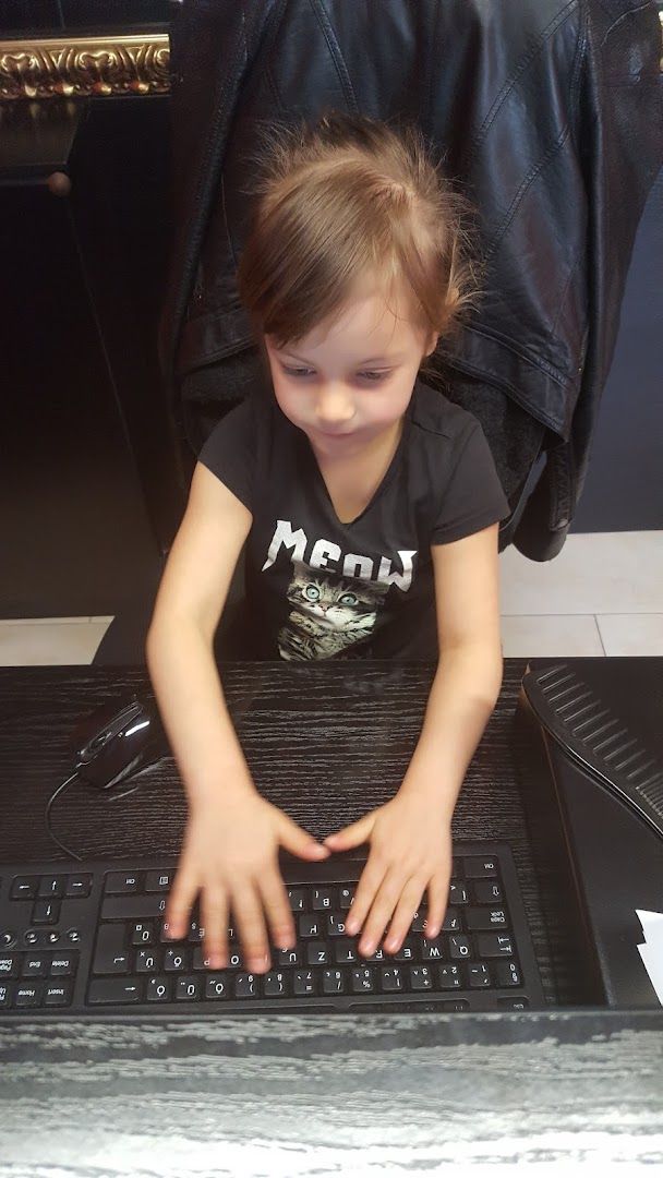 a little girl is playing with a keyboard