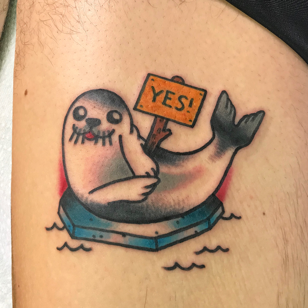 a narben tattoo of a seal with a sign in its mouth, dresden, germany