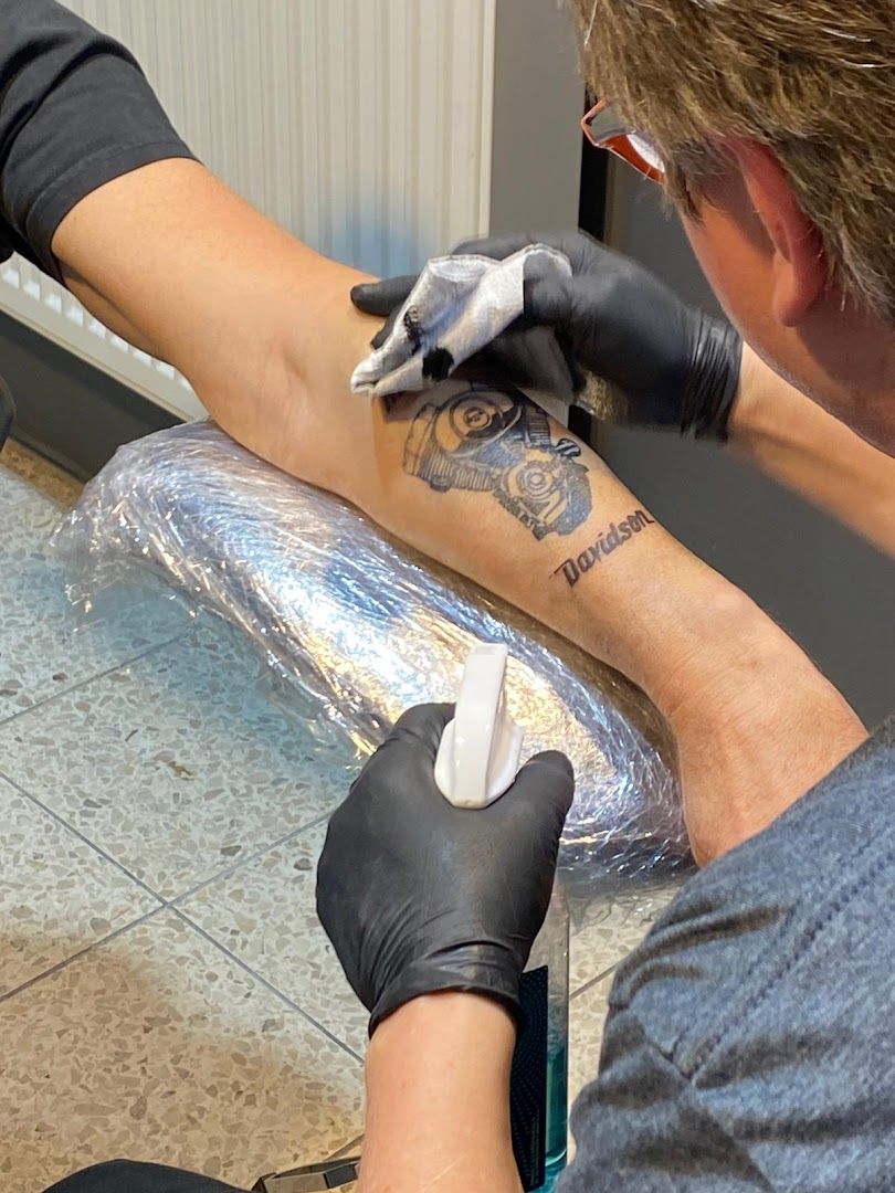 a man getting a narben tattoo on his arm, ansbach, germany