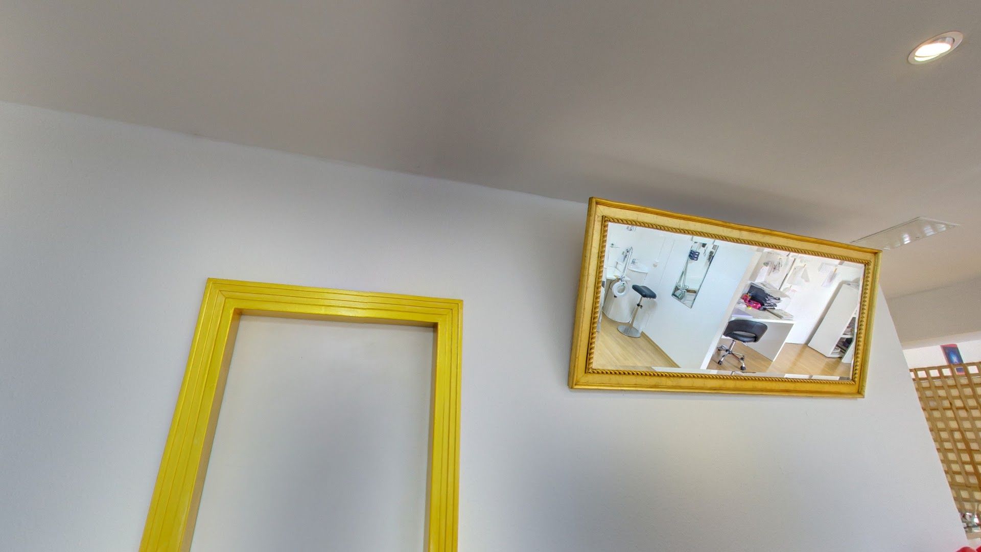 a mirror hanging on the wall above a yellow frame