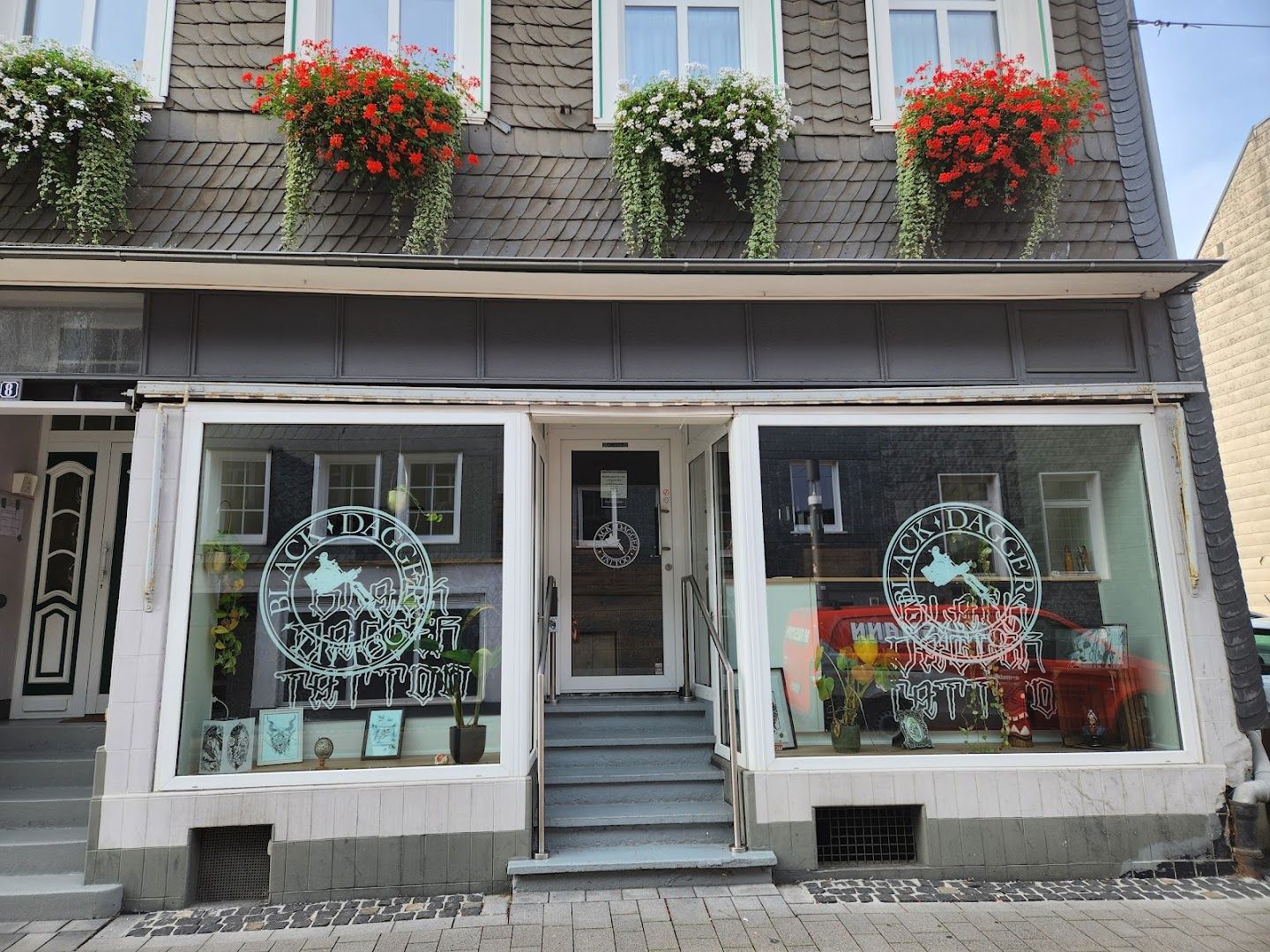 a storefront with flowers on the windows