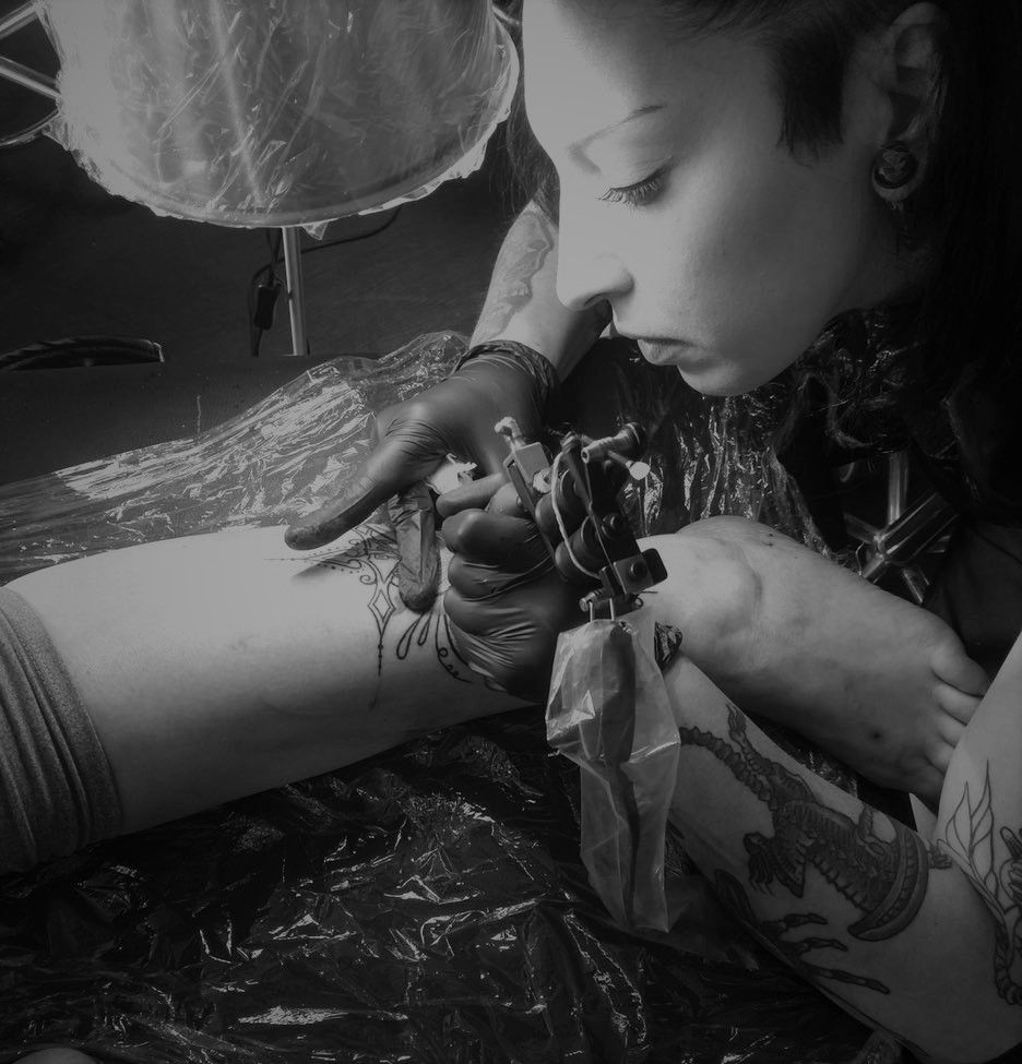 a woman is getting her narben tattoo done, berlin, germany