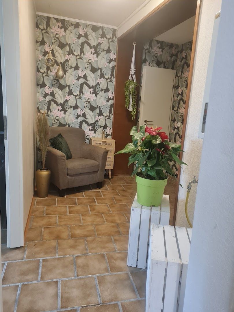 a living room with a couch and a wallpapered wall