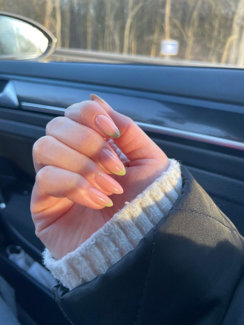 a woman's hand holding a yellow mani