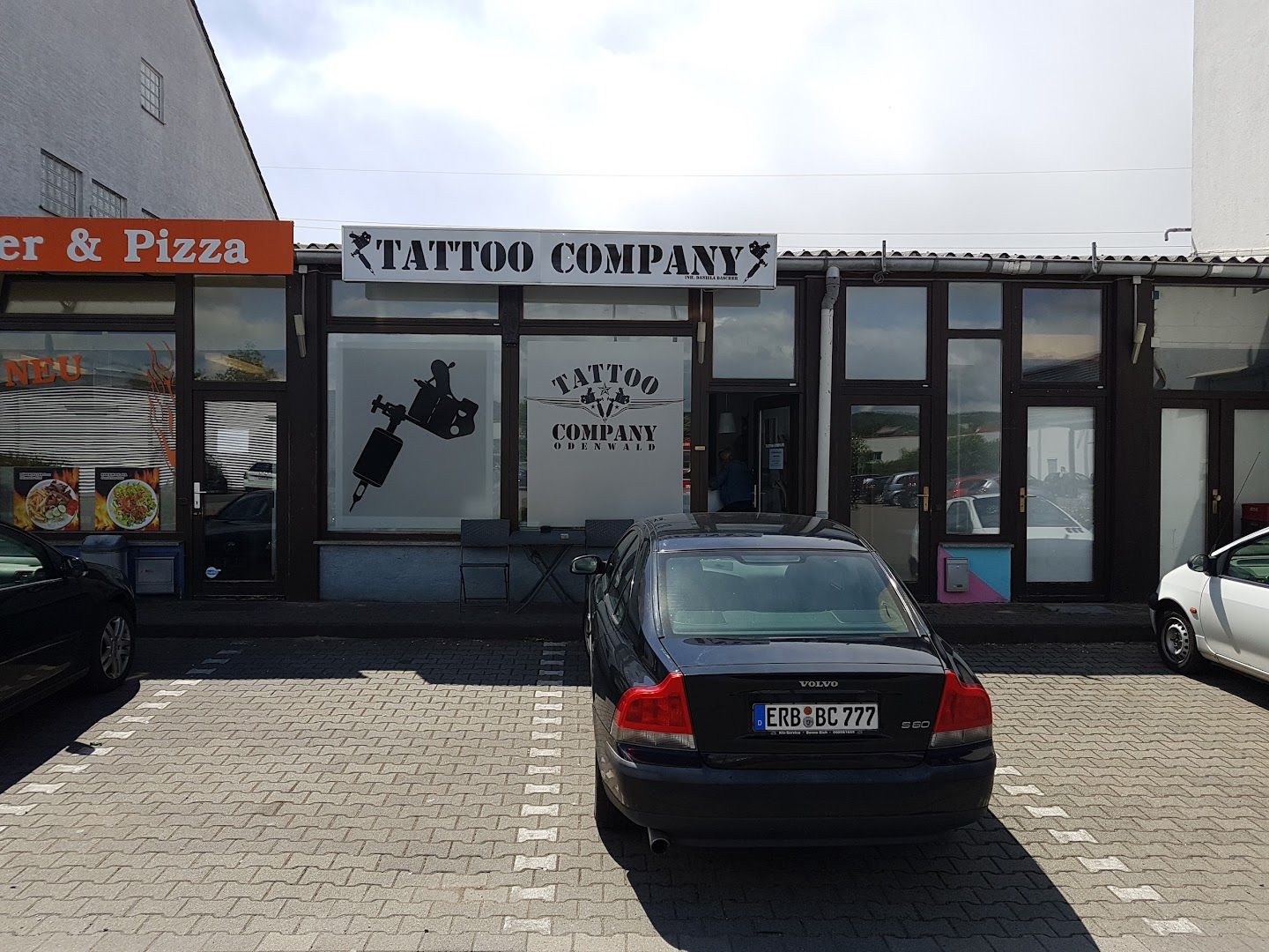 a car parked in front of a pizza shop