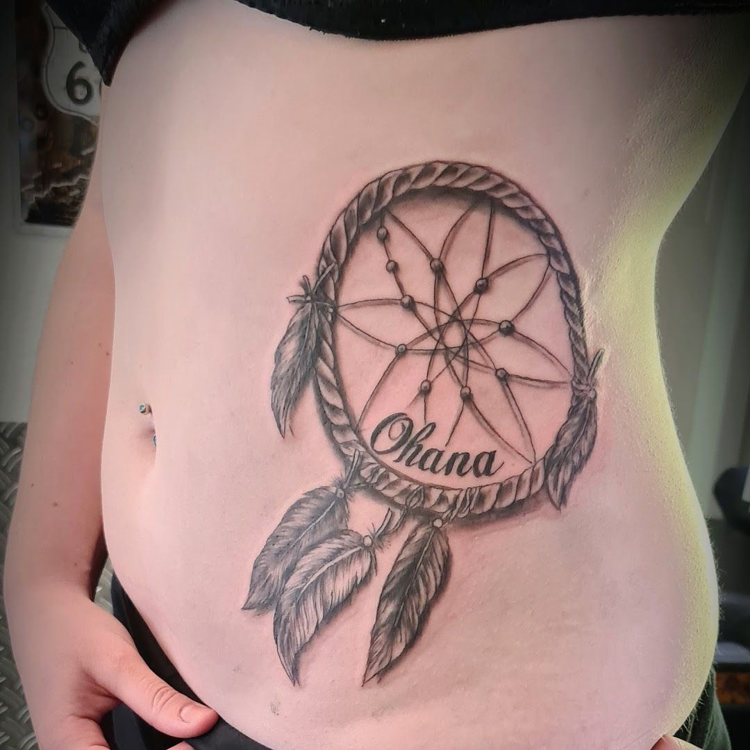 a woman's stomach with a dream catcher cover-up tattoo on it, rastatt, germany
