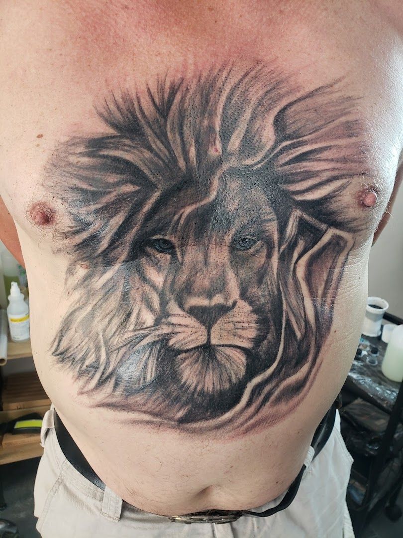 a man with a lion cover-up tattoo on his chest, dachau, germany