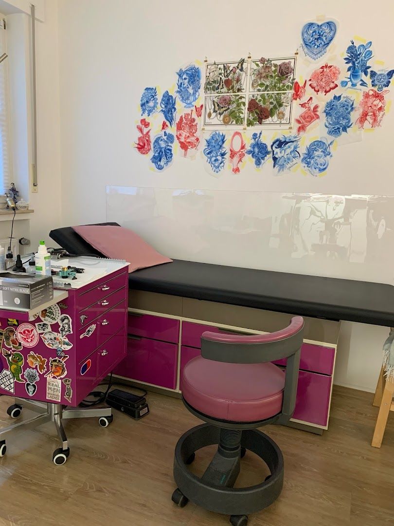 a pink desk with a black top and a white wall