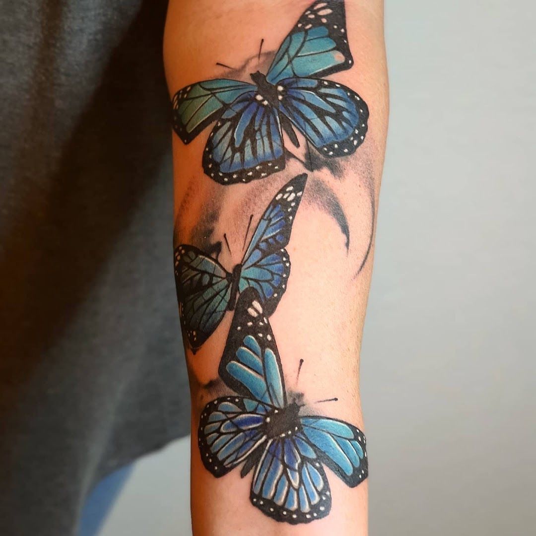 a narben tattoo of three blue butterflies on the arm, bonn, germany
