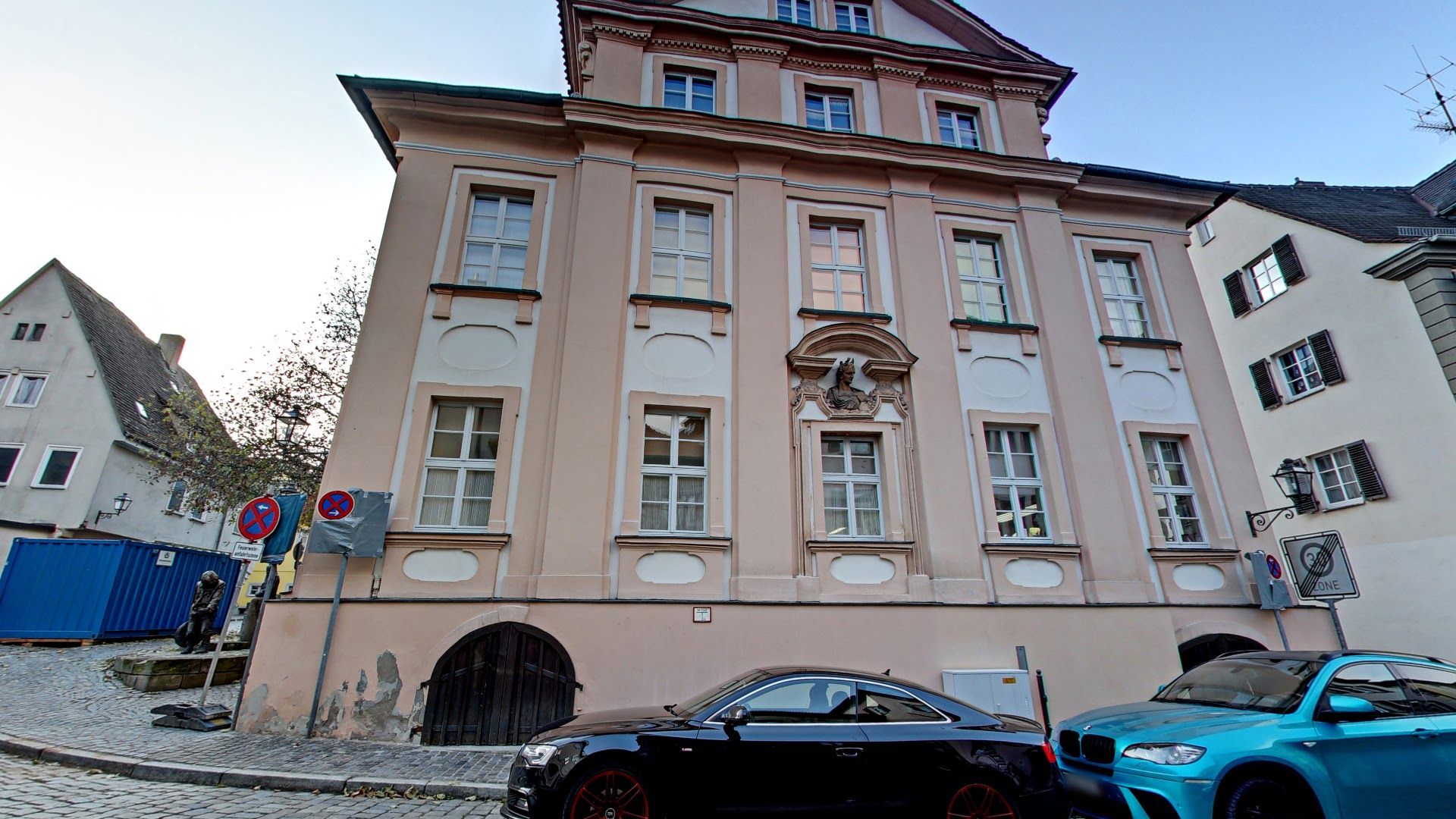 a pink building with a clock on the side