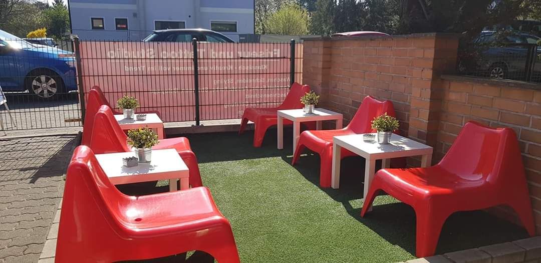 a red table and chairs on a green lawn