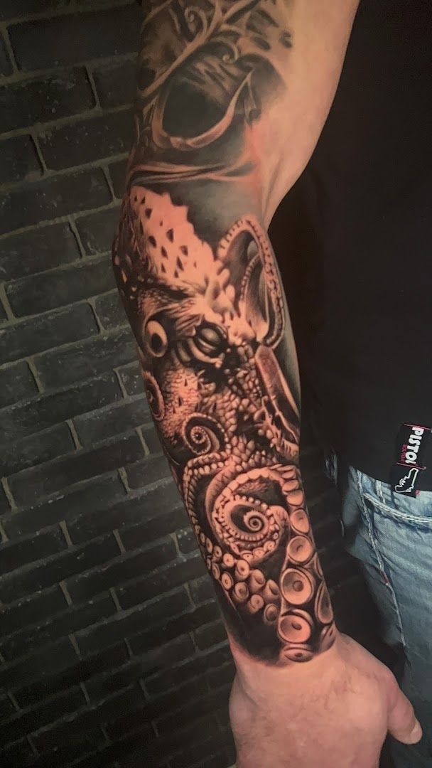 a man with a black and grey cover-up tattoo on his arm, kassel, germany