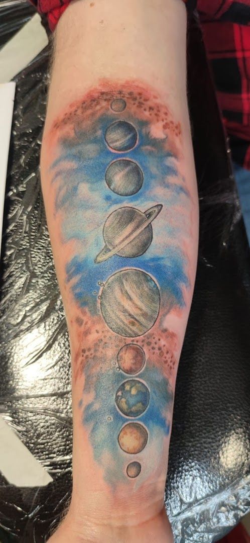 a cover-up tattoo of planets and stars on the arm, celle, germany