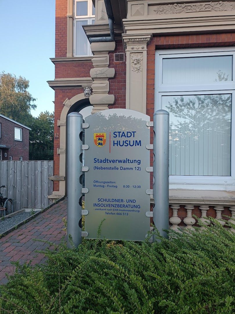 a sign in front of a house with a brick wall