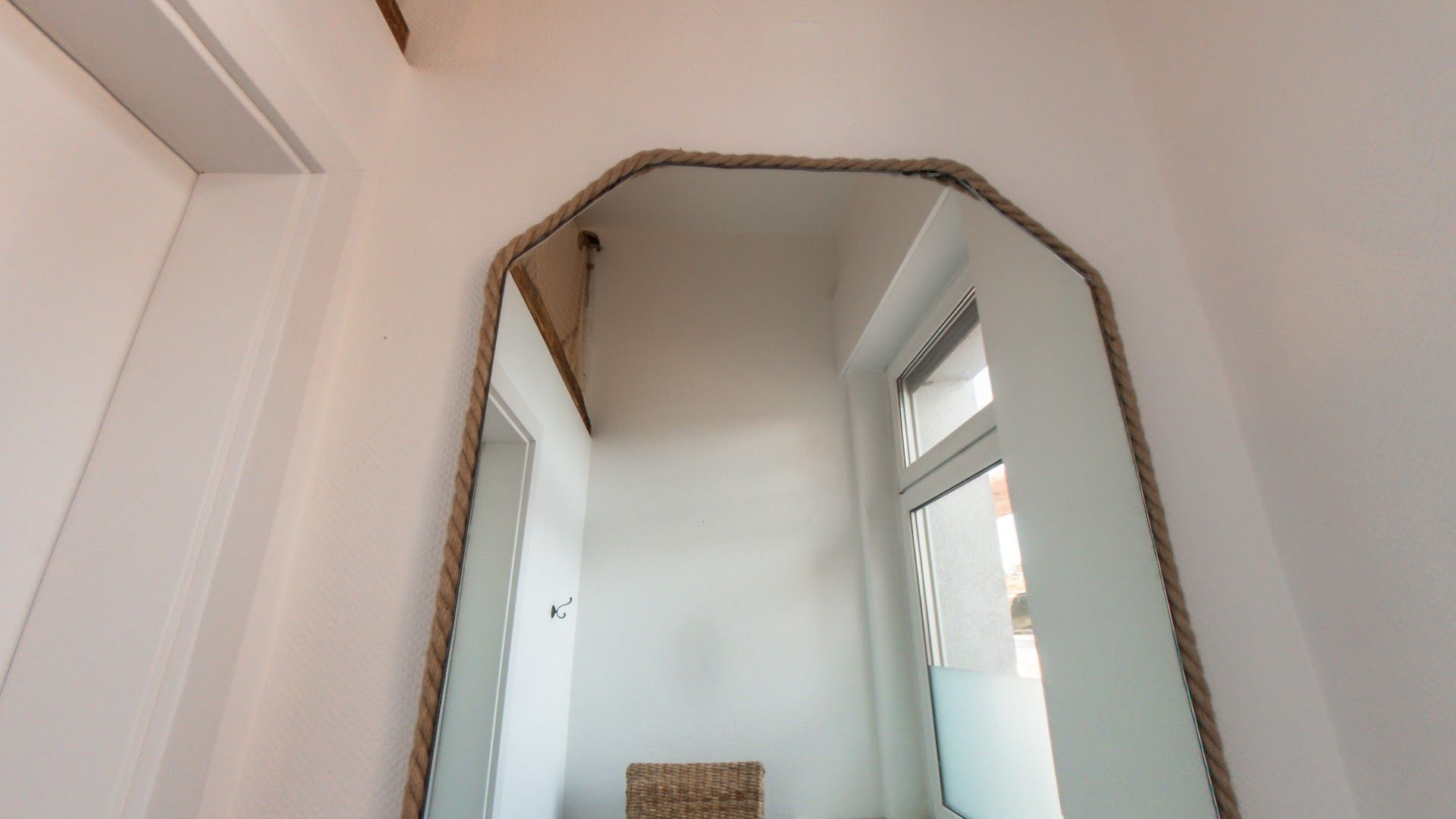 a mirror hanging on the wall above a chair