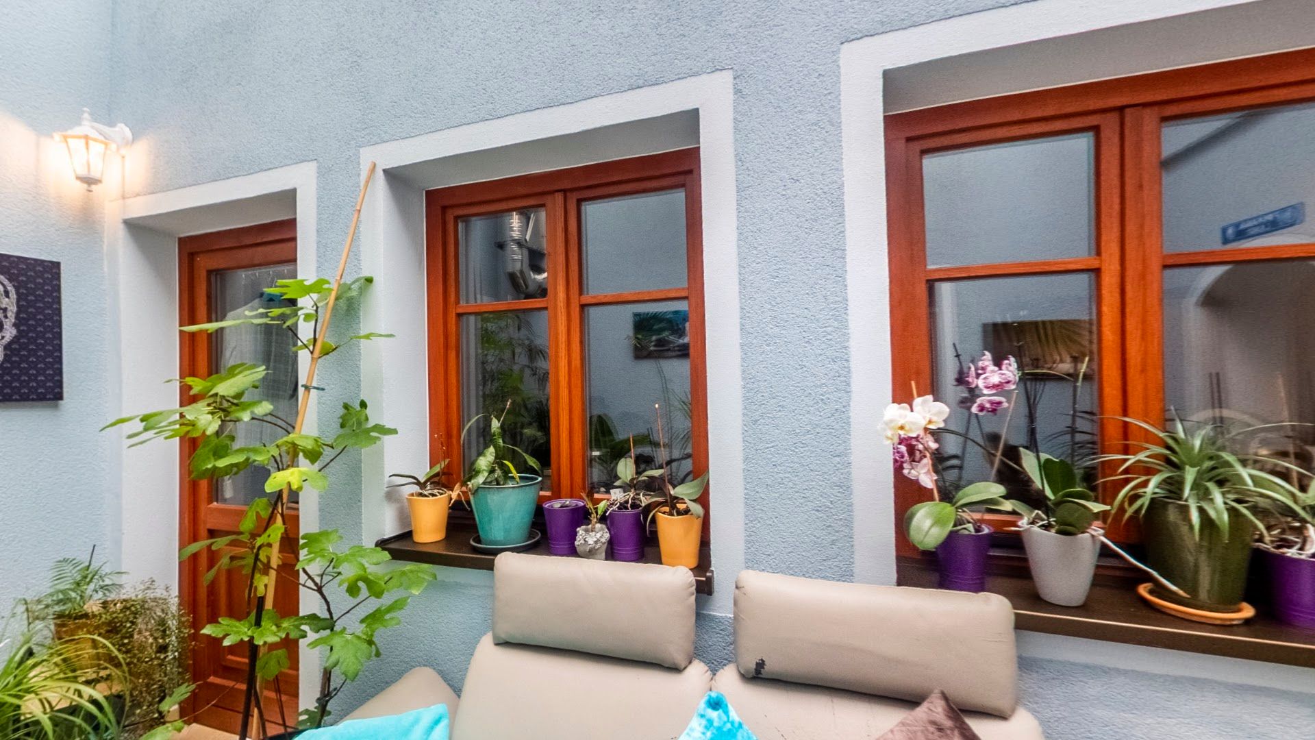 a patio with a couch and potted plants