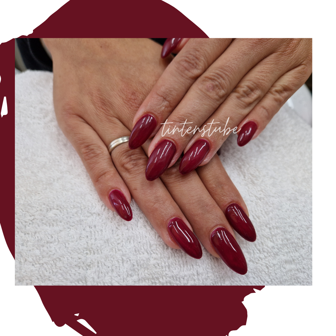 a woman's hand with red nails and a white towel