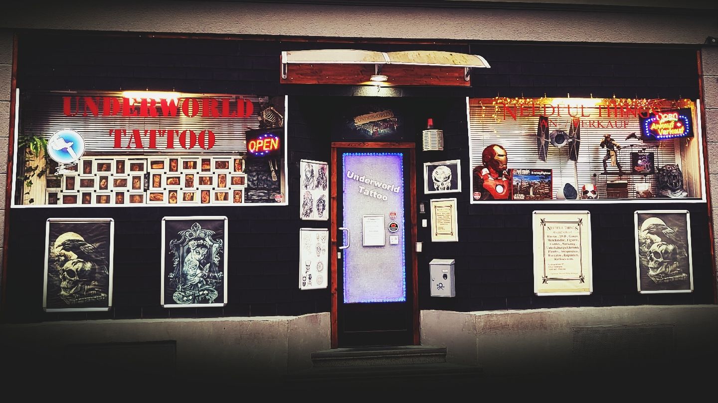 a store front with a sign and posters on the front