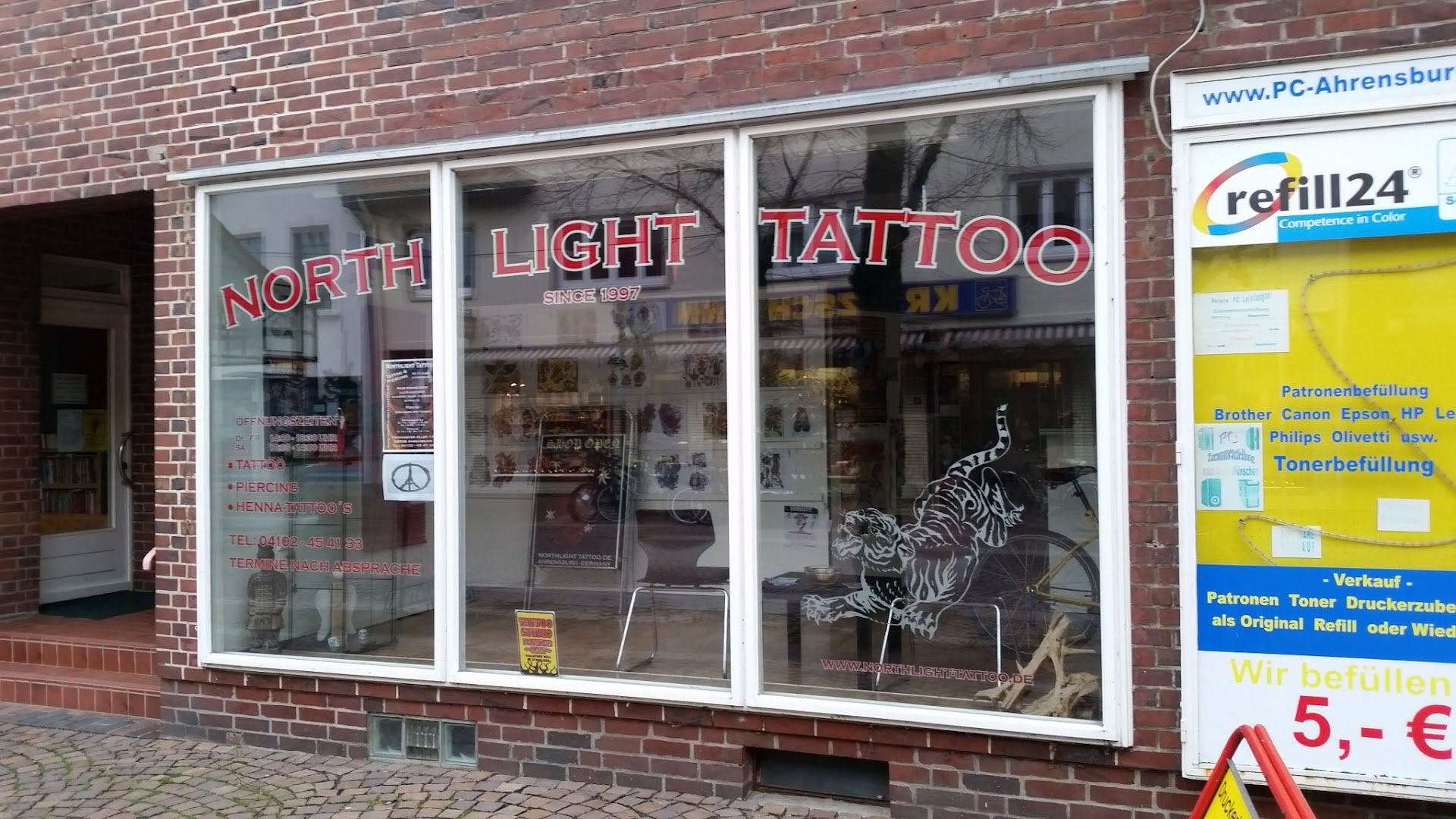 a store front with a sign that says north narben tattoo, stormarn, germany