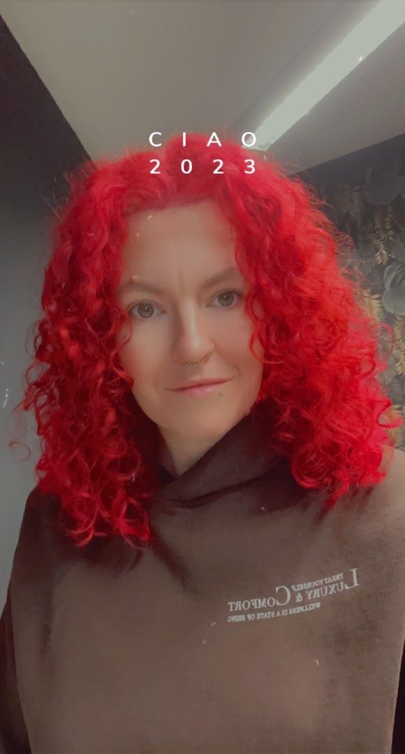 a woman with red hair and a brown shirt