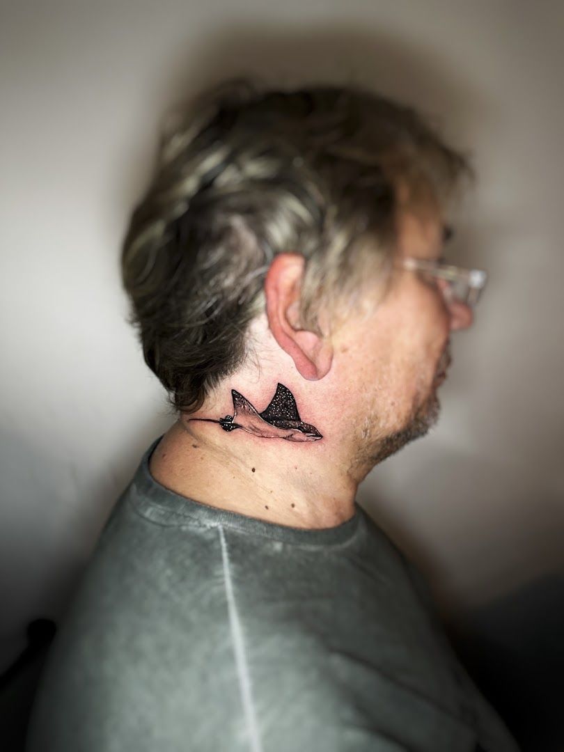 a man with a black bird japanische tattoos in leipzig on his neck, kassel, germany