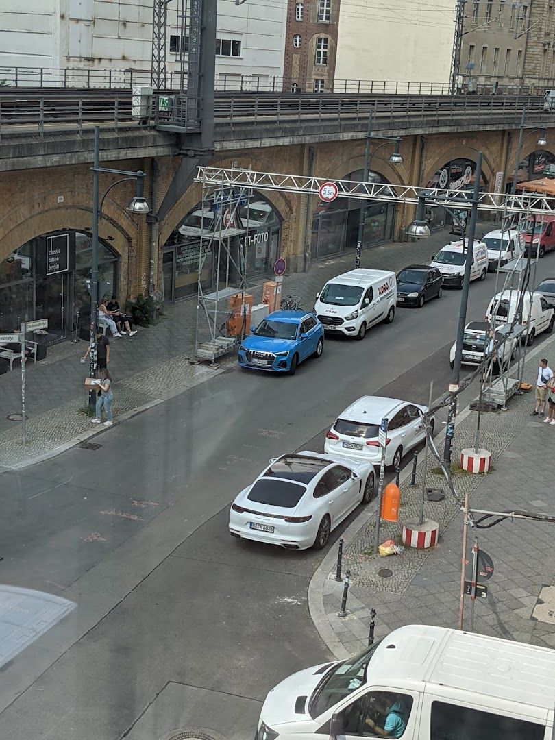 a street with cars parked on it and a bridge in the background