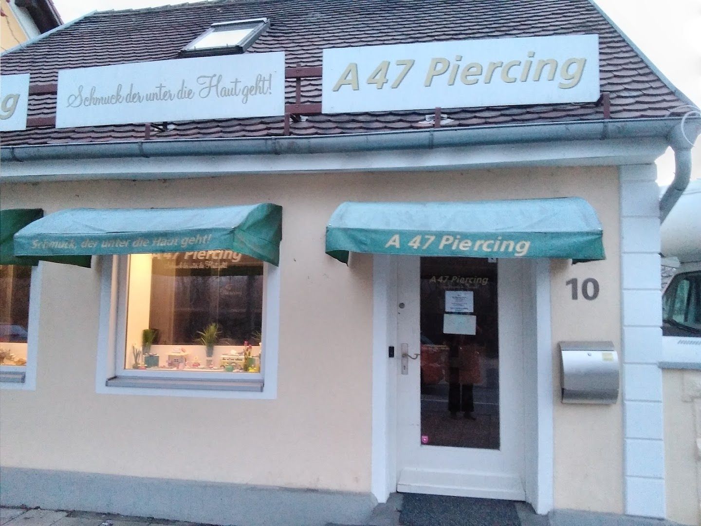 a white building with a green awning on the front