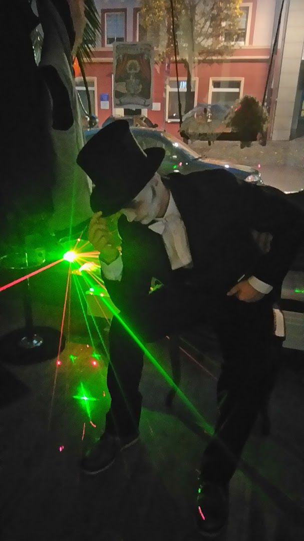 a man in a suit and hat is using laserss