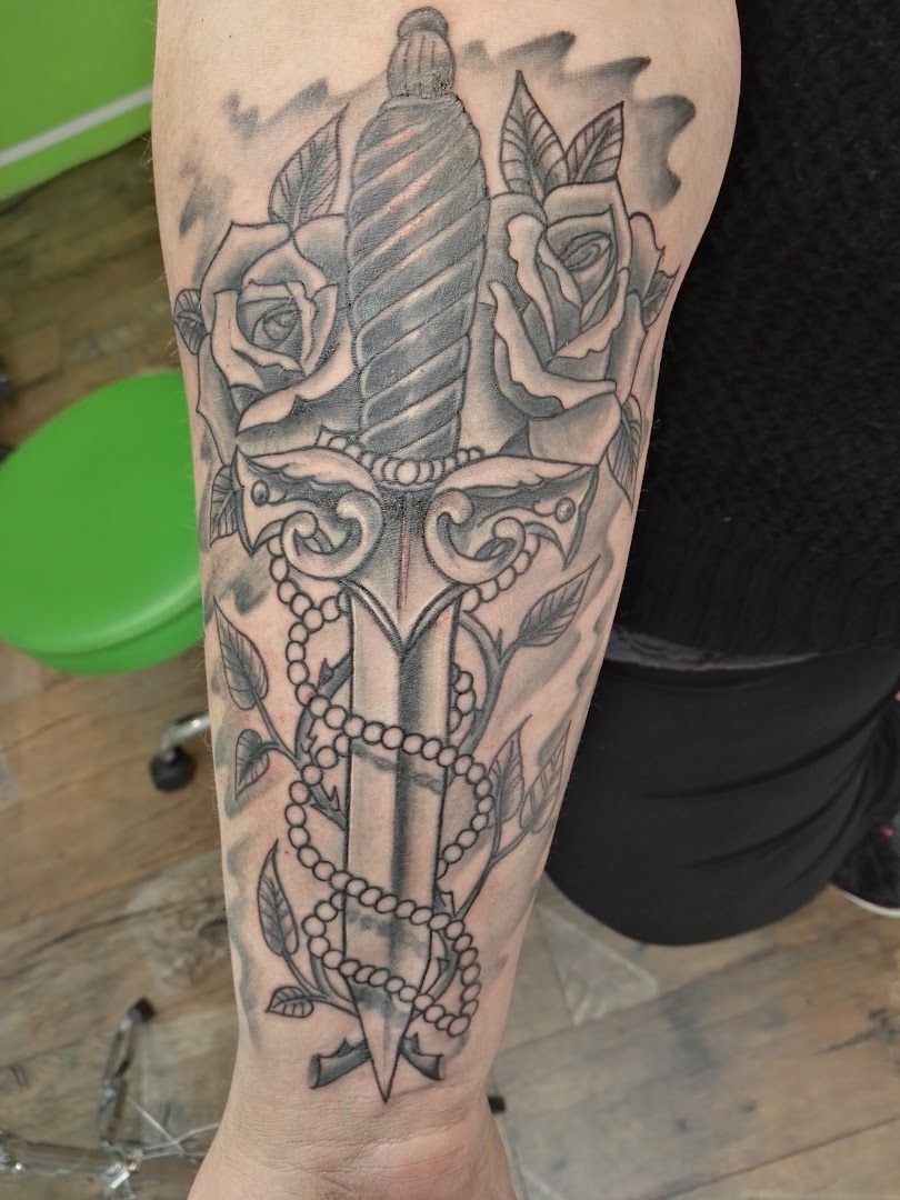 a narben tattoo with a dagger and roses on the arm, freudenstadt, germany