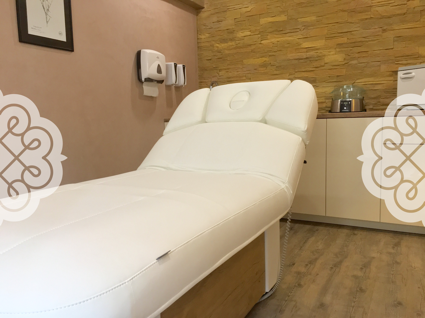 a massage room with a white bed and a wooden wall