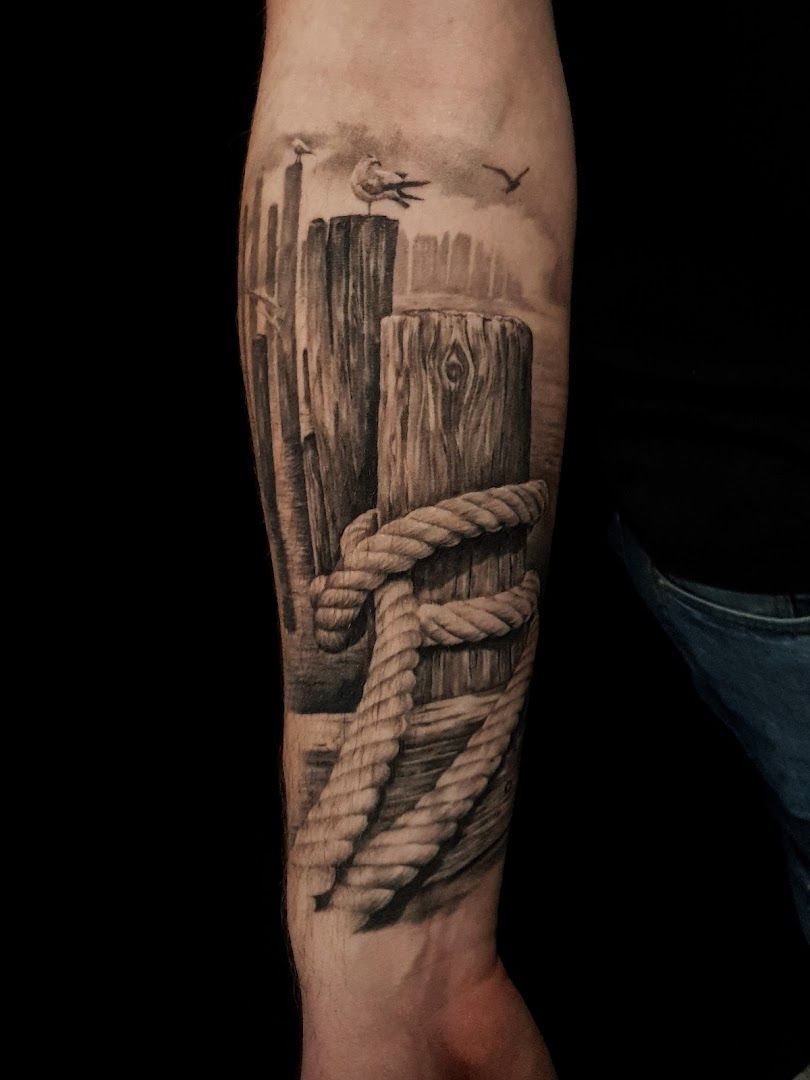 a man's forearm with a black and white japanische tattoos in leipzig of a wooden fence, bodenseekreis, germany